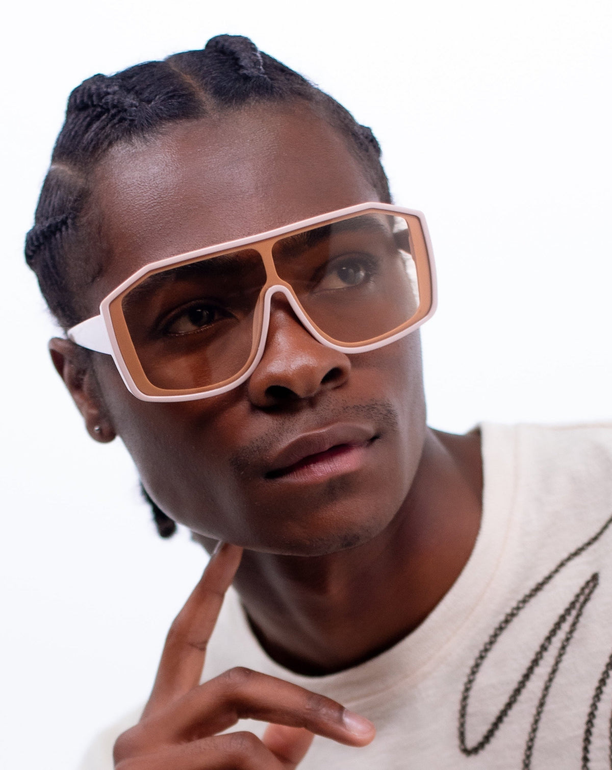 Man in a white sweater wearing the Privado Pygmy sunglasses in black, looking upward