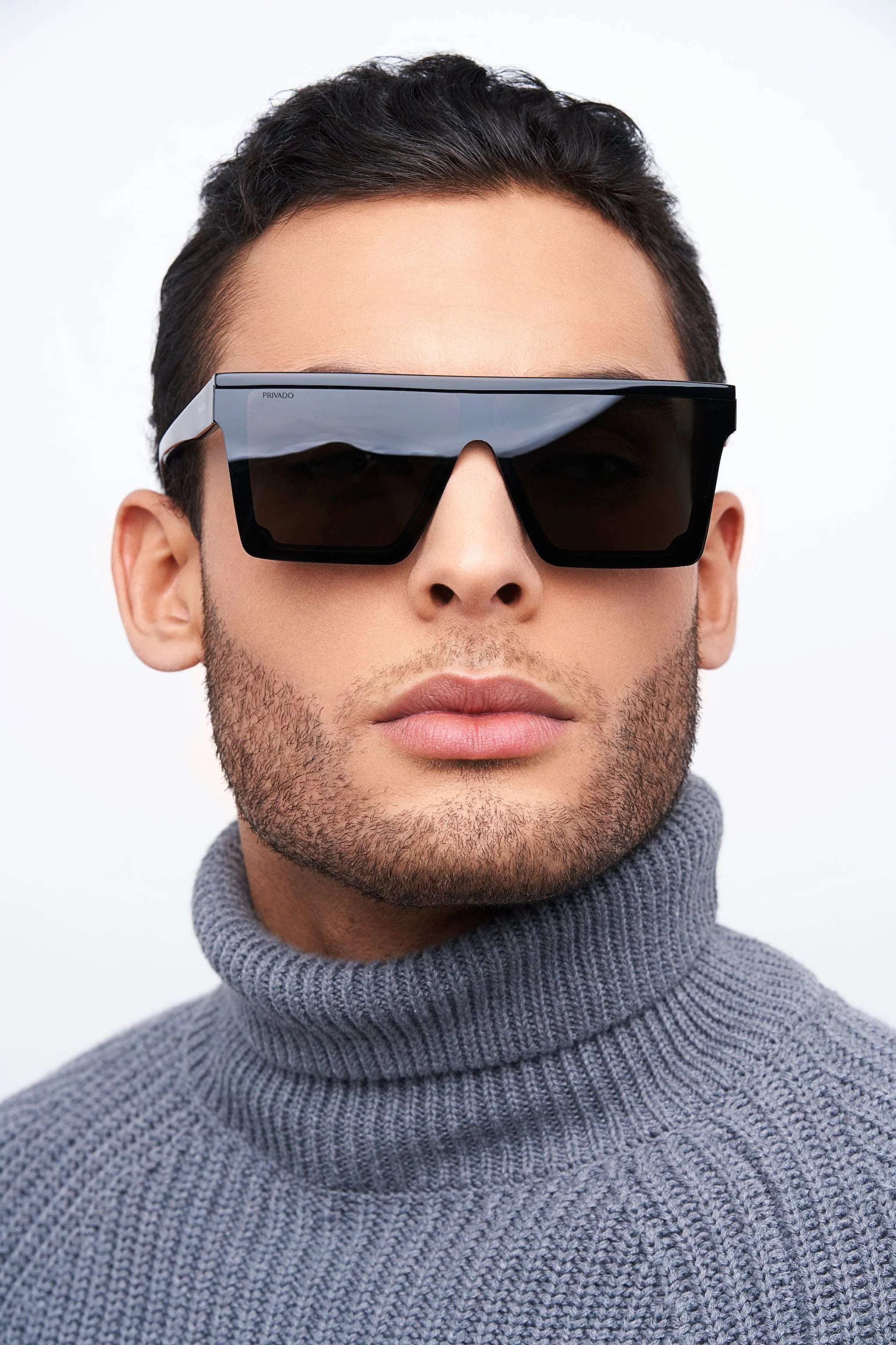man in gray sweater and black square sunglasses