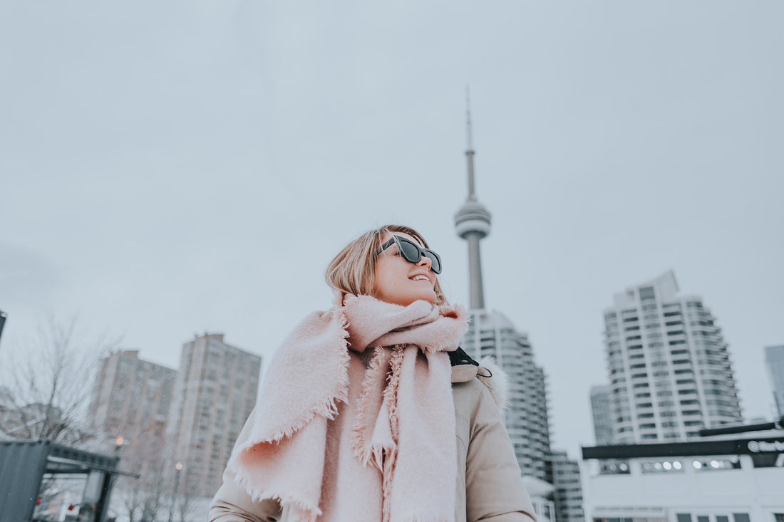 Woman wearing coat, scarf and sunglasses in the winter